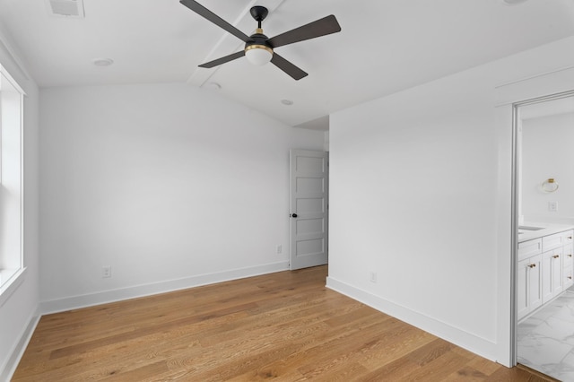 unfurnished room with light wood-type flooring, visible vents, baseboards, and vaulted ceiling