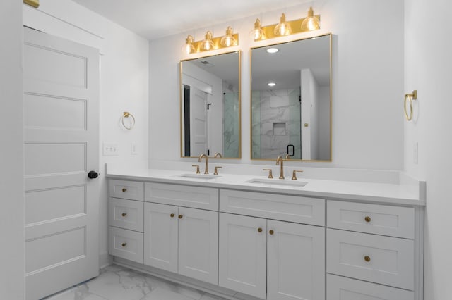 full bath with marble finish floor, a sink, a marble finish shower, and double vanity