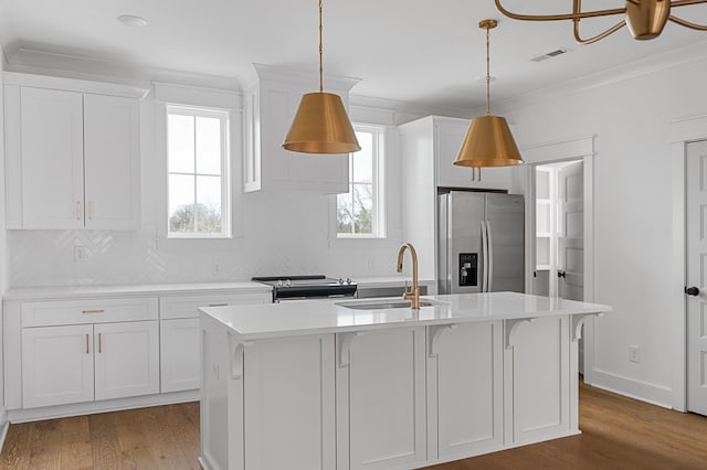 kitchen featuring wood finished floors, a sink, visible vents, light countertops, and appliances with stainless steel finishes