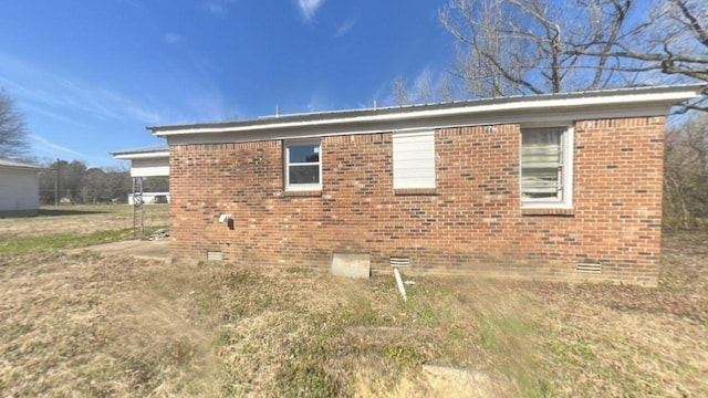 view of side of property with brick siding and crawl space