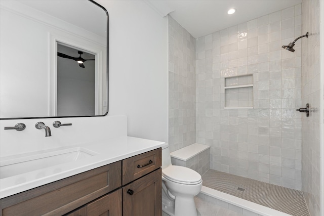 bathroom featuring vanity, a tile shower, toilet, and recessed lighting