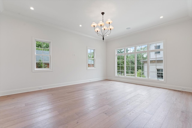 unfurnished room with light wood-style floors, baseboards, a wealth of natural light, and crown molding