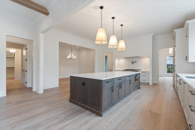 kitchen featuring tasteful backsplash, white cabinets, ornamental molding, light countertops, and light wood-style floors