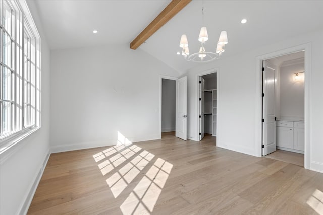 unfurnished bedroom with a notable chandelier, vaulted ceiling with beams, a spacious closet, light wood-type flooring, and baseboards