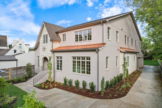 view of front of house with brick siding and fence