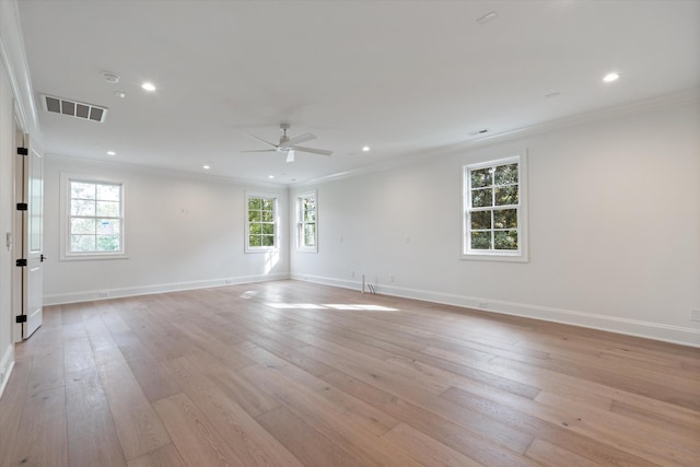 spare room featuring light wood-type flooring, visible vents, and crown molding