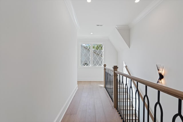 hall featuring light wood-style flooring, baseboards, crown molding, and an upstairs landing