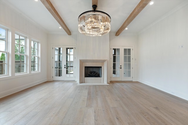 unfurnished living room featuring light wood-style floors, french doors, beamed ceiling, and baseboards