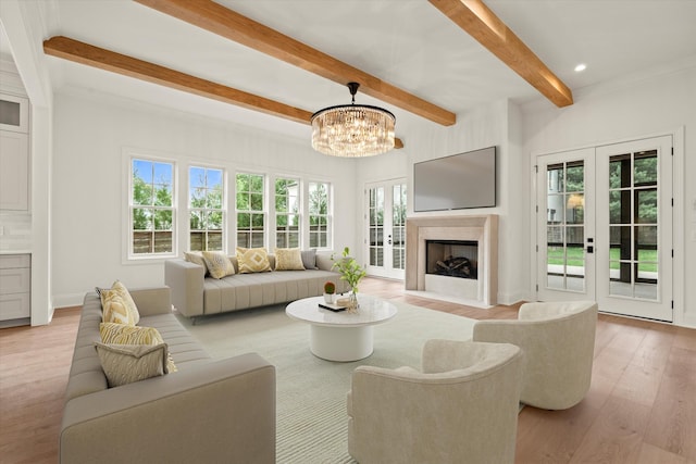 living room with light wood-style floors, french doors, a chandelier, and beamed ceiling