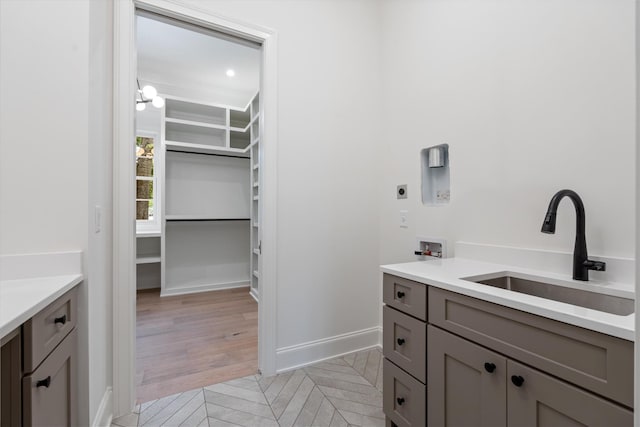 bathroom featuring parquet floors, baseboards, and vanity