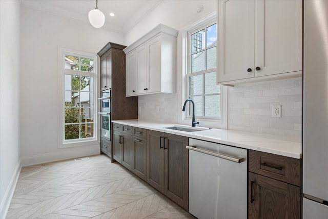 kitchen with a healthy amount of sunlight, decorative backsplash, stainless steel appliances, and a sink