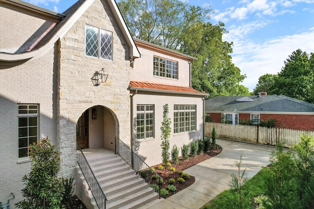 view of front of home featuring stone siding and fence