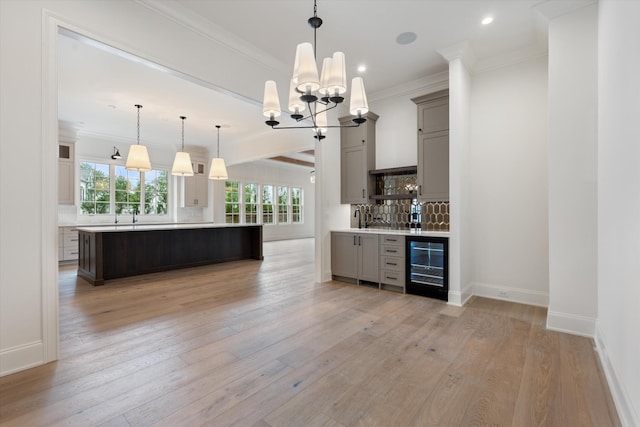 kitchen featuring wine cooler, light countertops, light wood-type flooring, gray cabinets, and tasteful backsplash