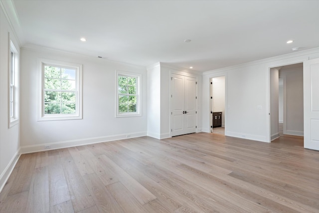 spare room with light wood-style flooring, baseboards, and crown molding