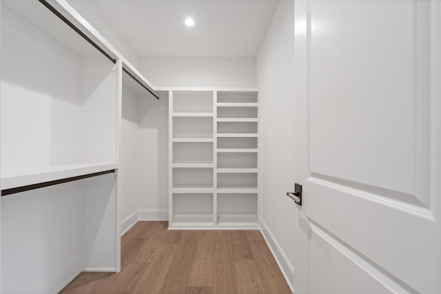 walk in closet featuring light wood-type flooring and a barn door