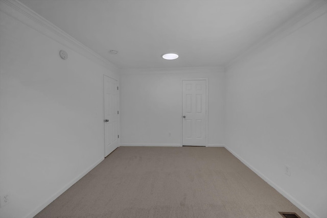 spare room featuring ornamental molding, light colored carpet, and baseboards