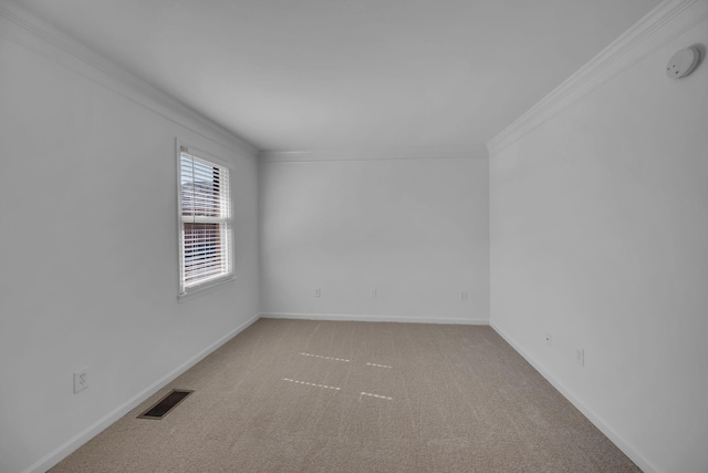 empty room featuring carpet floors, visible vents, crown molding, and baseboards