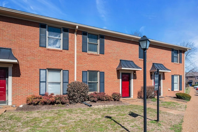 multi unit property featuring a front yard and brick siding