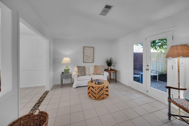 tiled living area featuring baseboards, french doors, visible vents, and crown molding