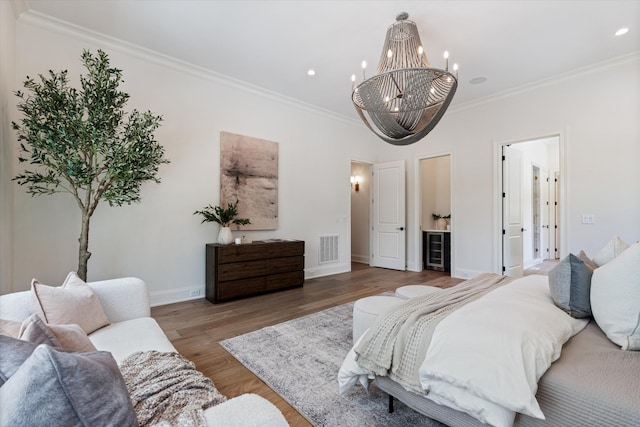 bedroom featuring ornamental molding, wood finished floors, visible vents, and baseboards