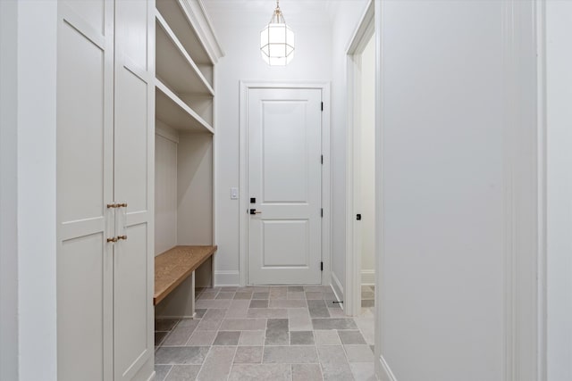 mudroom with baseboards and stone finish floor