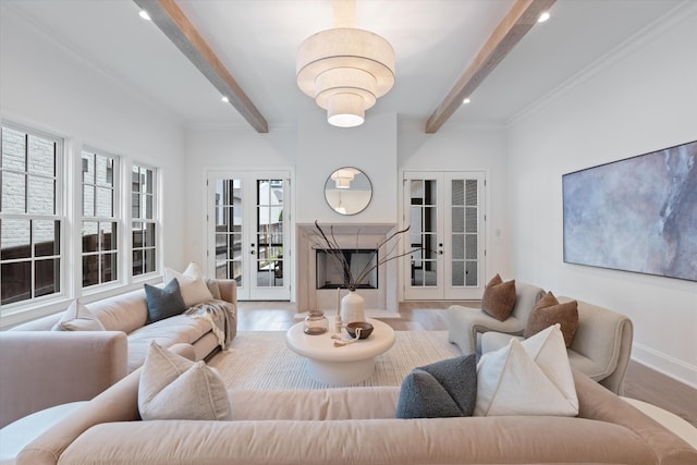 living area with french doors, beamed ceiling, baseboards, and wood finished floors