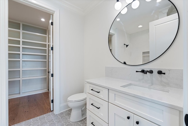 bathroom featuring ornamental molding, vanity, toilet, and recessed lighting