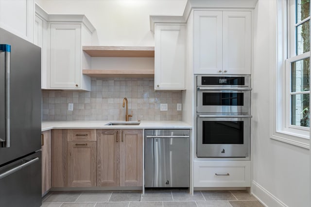 kitchen featuring open shelves, a wealth of natural light, stainless steel appliances, and a sink