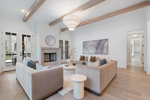 living area with light wood-style floors, a fireplace, beamed ceiling, and french doors