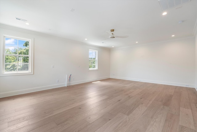 spare room with ornamental molding, visible vents, and light wood-style floors