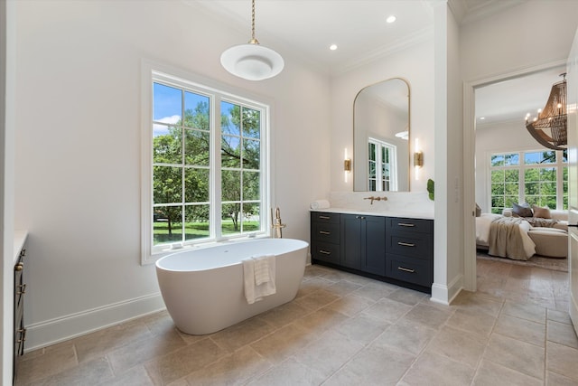 ensuite bathroom featuring baseboards, connected bathroom, a soaking tub, crown molding, and vanity