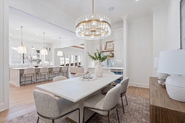 dining room with baseboards, ornamental molding, light wood-type flooring, a notable chandelier, and recessed lighting