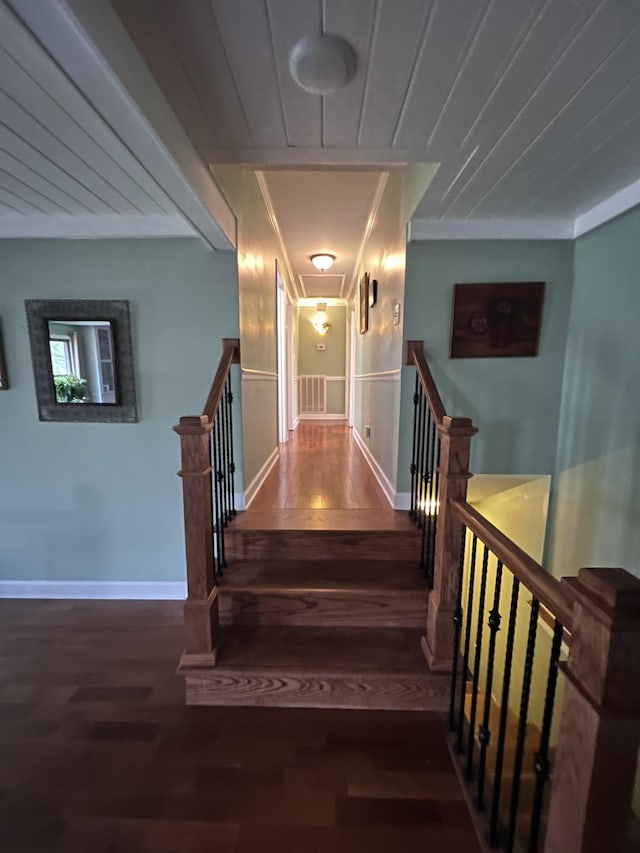 staircase with baseboards, wood finished floors, and ornamental molding