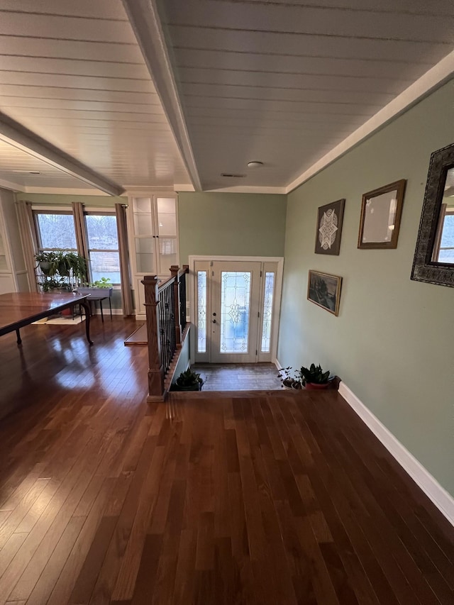 entryway featuring lofted ceiling with beams, wood-type flooring, and baseboards