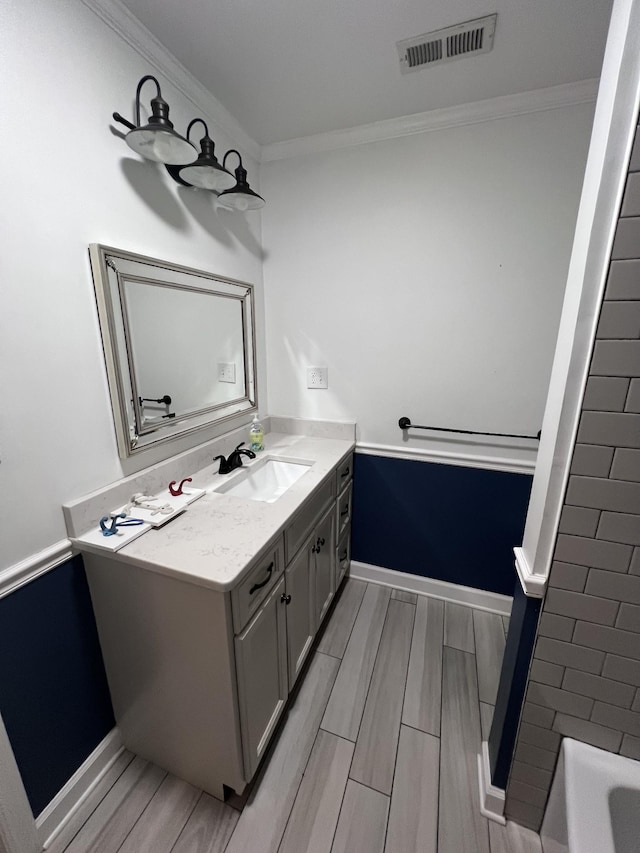 full bathroom with a tub to relax in, visible vents, ornamental molding, vanity, and baseboards