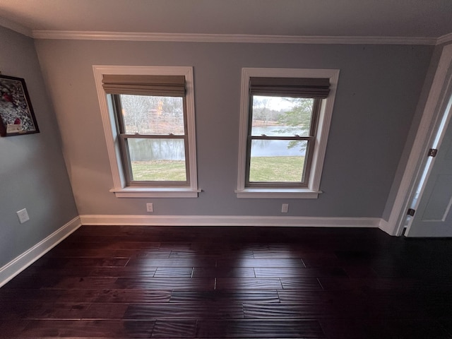 unfurnished room featuring dark wood-style floors, ornamental molding, and baseboards