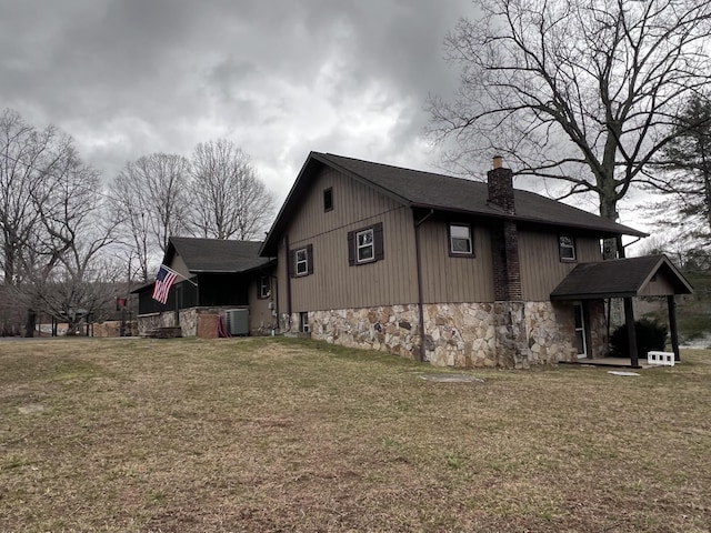 view of property exterior featuring central air condition unit, stone siding, a chimney, and a lawn