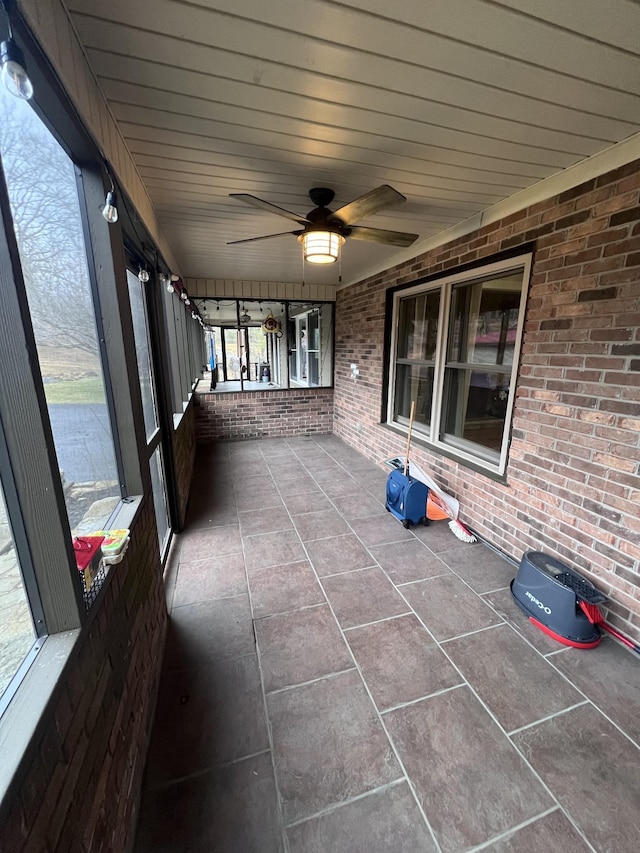 unfurnished sunroom with ceiling fan