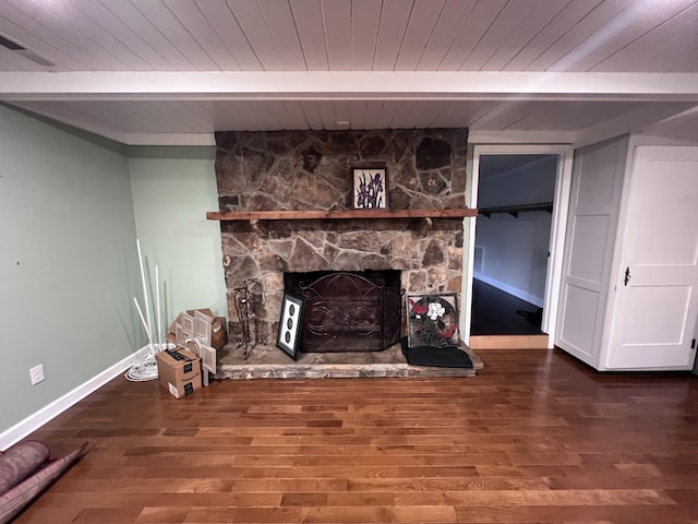 unfurnished living room with beam ceiling, a fireplace, wood finished floors, wooden ceiling, and baseboards