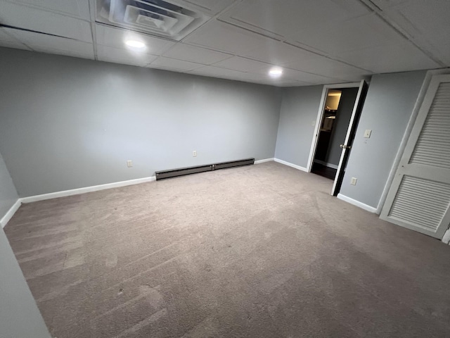 finished basement featuring carpet floors, a baseboard radiator, a paneled ceiling, visible vents, and baseboards