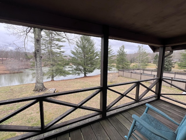 wooden terrace featuring a water view and fence