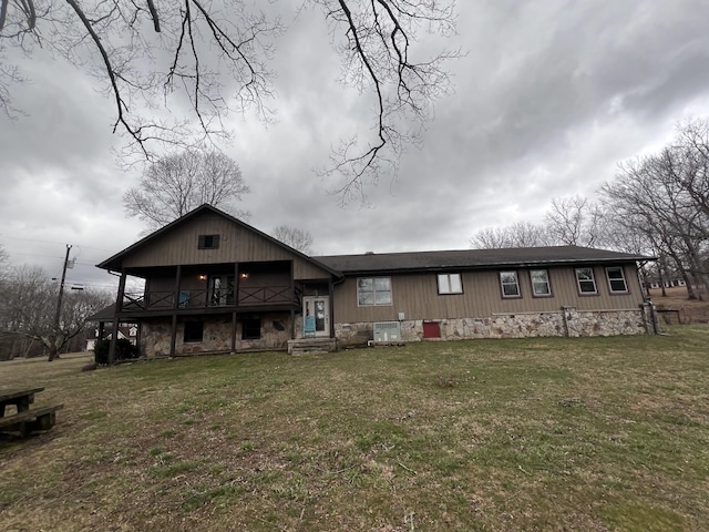 view of front of home with stone siding, a front lawn, and central air condition unit