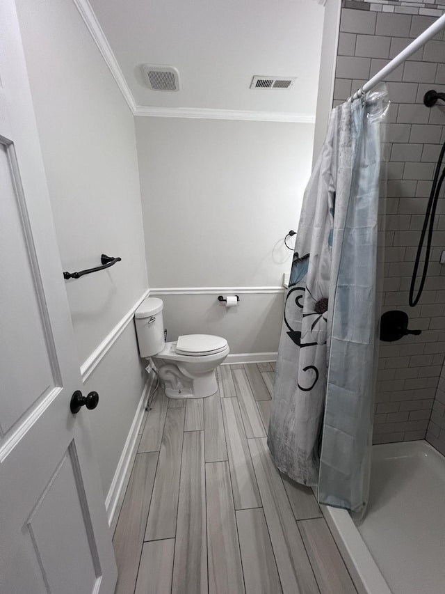 full bath featuring baseboards, visible vents, toilet, a tile shower, and crown molding