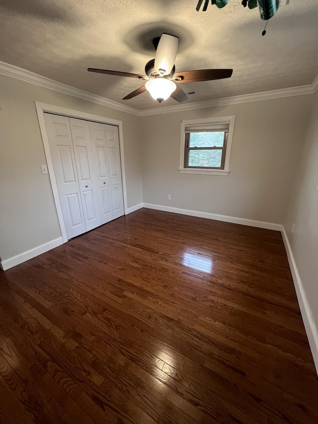 unfurnished bedroom with baseboards, ornamental molding, and dark wood-style flooring