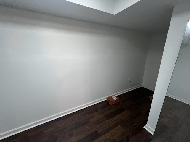 spare room with dark wood finished floors and baseboards