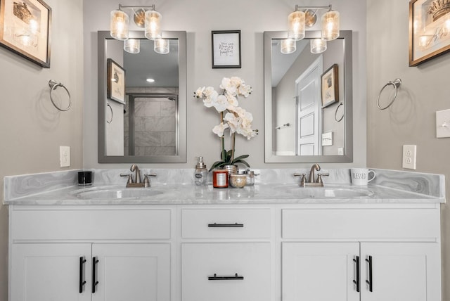 bathroom featuring a tile shower, double vanity, and a sink