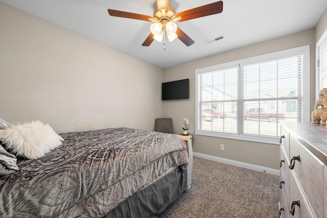 carpeted bedroom with ceiling fan, visible vents, and baseboards