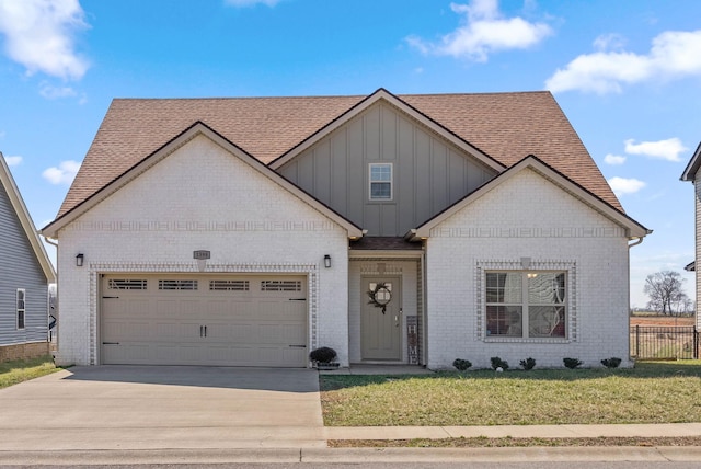 view of front of home featuring brick siding, board and batten siding, fence, a garage, and a front lawn