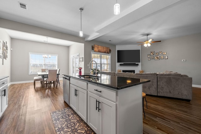 kitchen with a fireplace, visible vents, dark wood-type flooring, a sink, and dishwasher