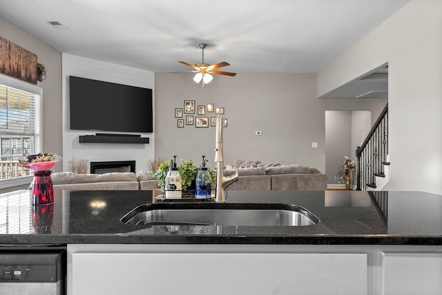 kitchen with dishwasher, a fireplace, open floor plan, and a ceiling fan